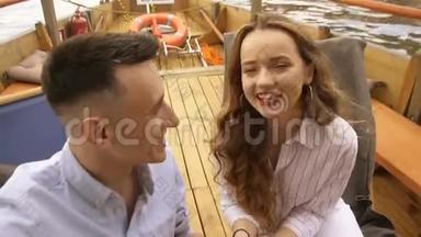 年轻的男人和女人兴高采烈地在船上露天自拍。 自拍视频-浪漫情侣日落自拍视频